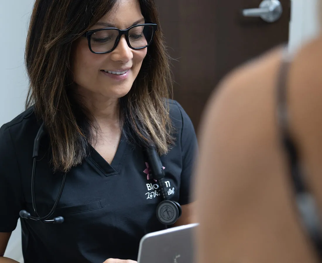 A Bloom La Vie Health clinician smiling as she works with a patient