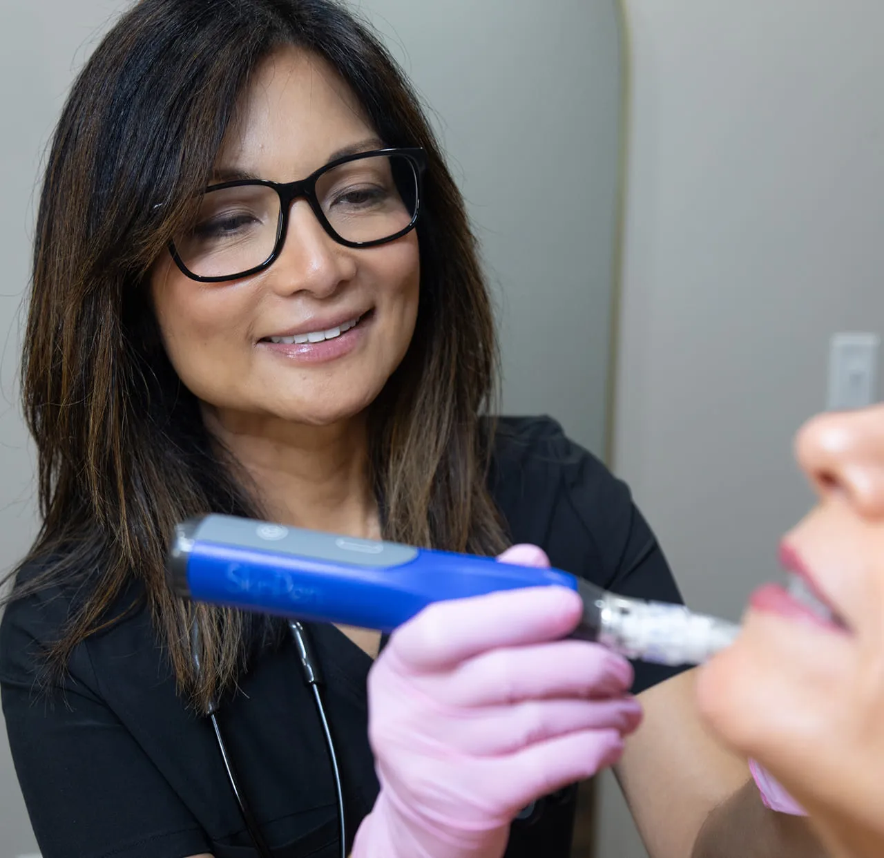 A provider holding a SkinPen microneedling device before a treatment