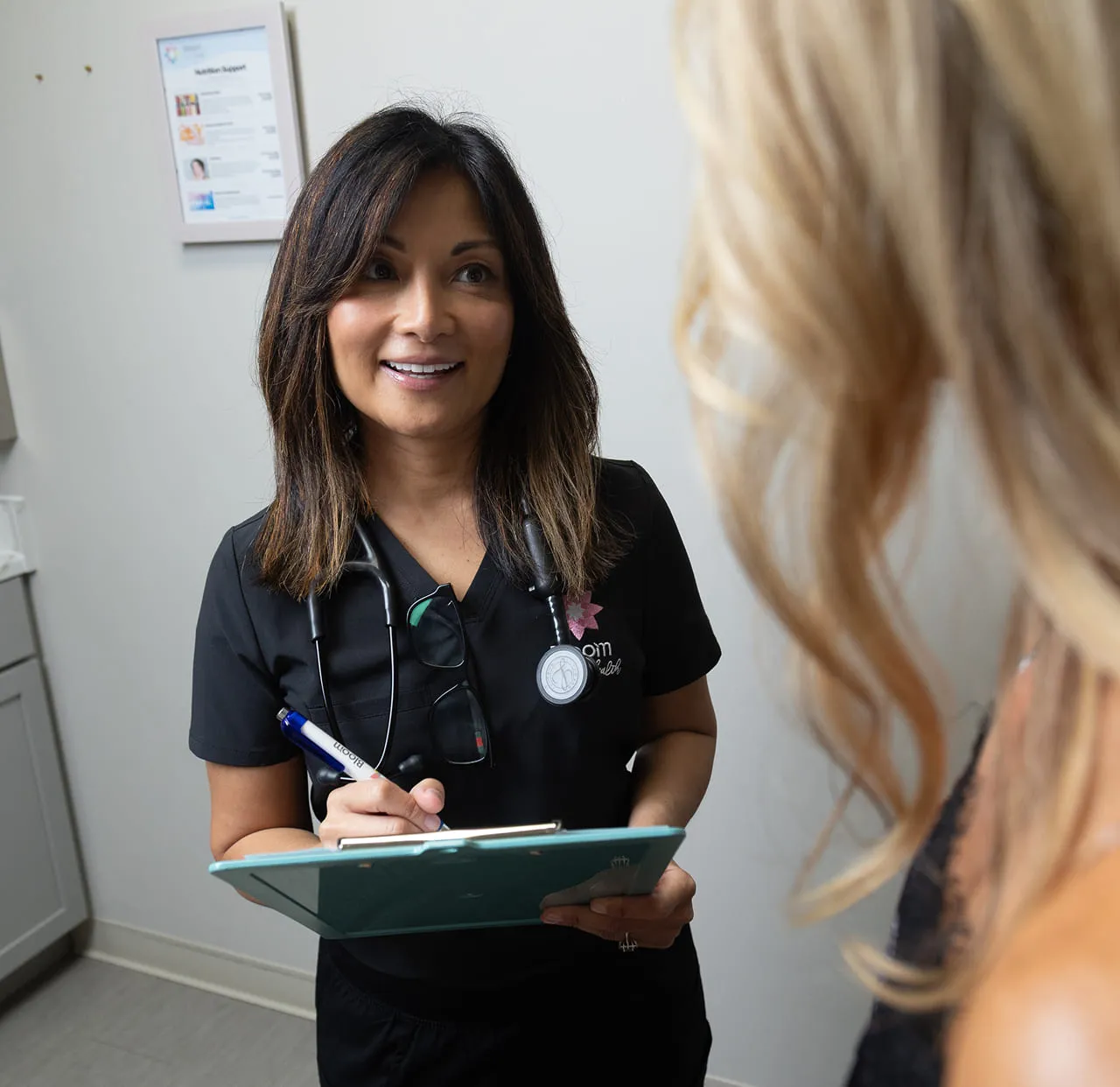 Dr. Nedeau taking notes during a one-to-one consultation